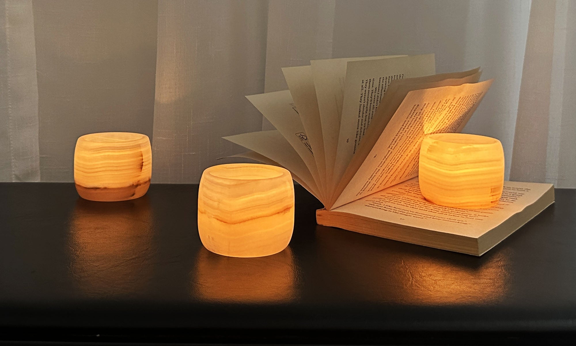 Marble and onyx candle holders glowing softly in a refined modern interior