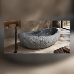 Veyra sculptural Charcoal Mist Granite soaking bathtub in a warm architectural luxury bathroom, styled visualization