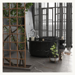 Yetta freestanding Portoro Black Marble soaking bathtub in a dark luxury bathroom setting