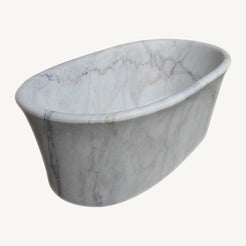 Elara freestanding Ivory Cloud Marble bathtub, three-quarter studio view showing the flared rolled rim