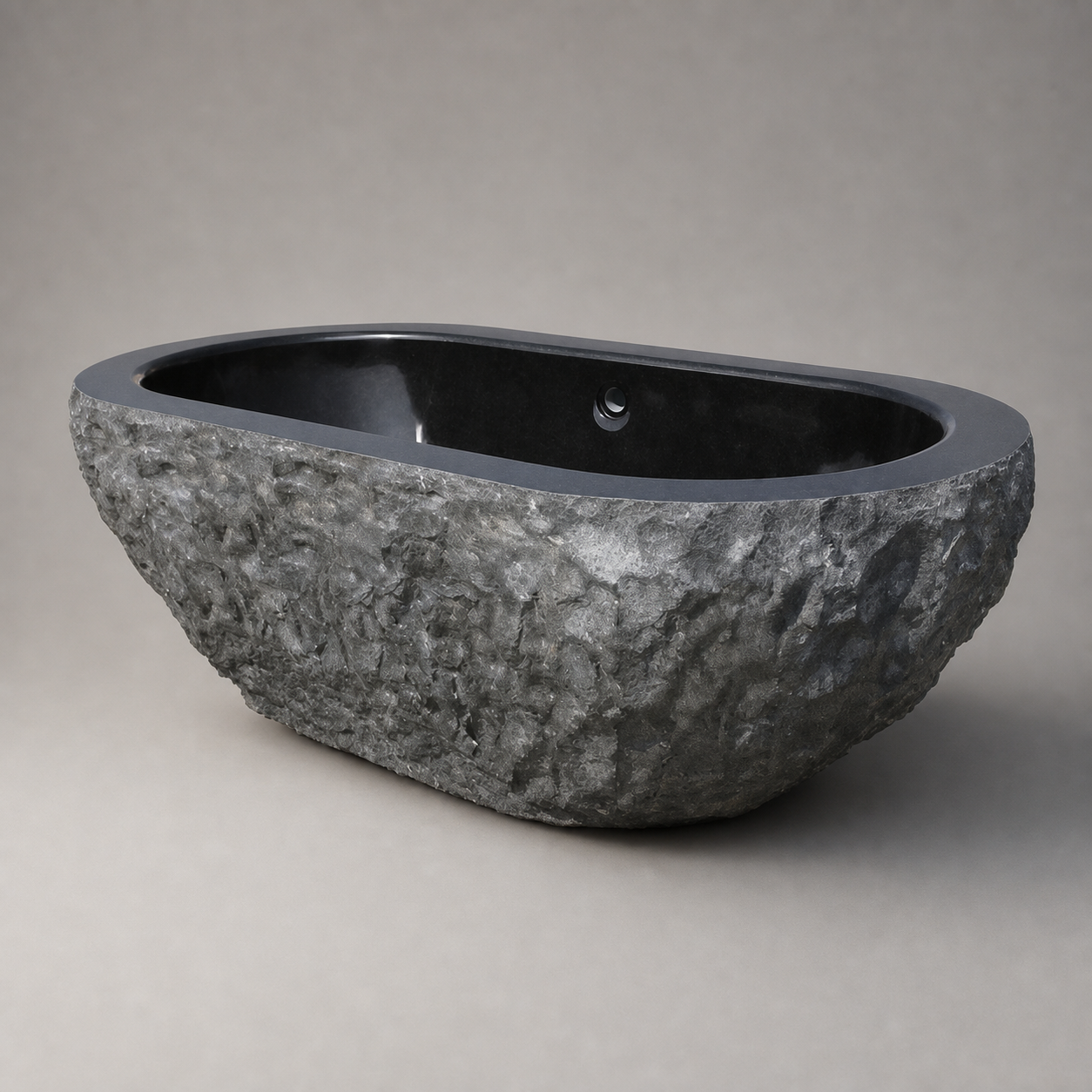 Arden freestanding Natural Black Granite bathtub with rough-chiseled exterior, studio angle