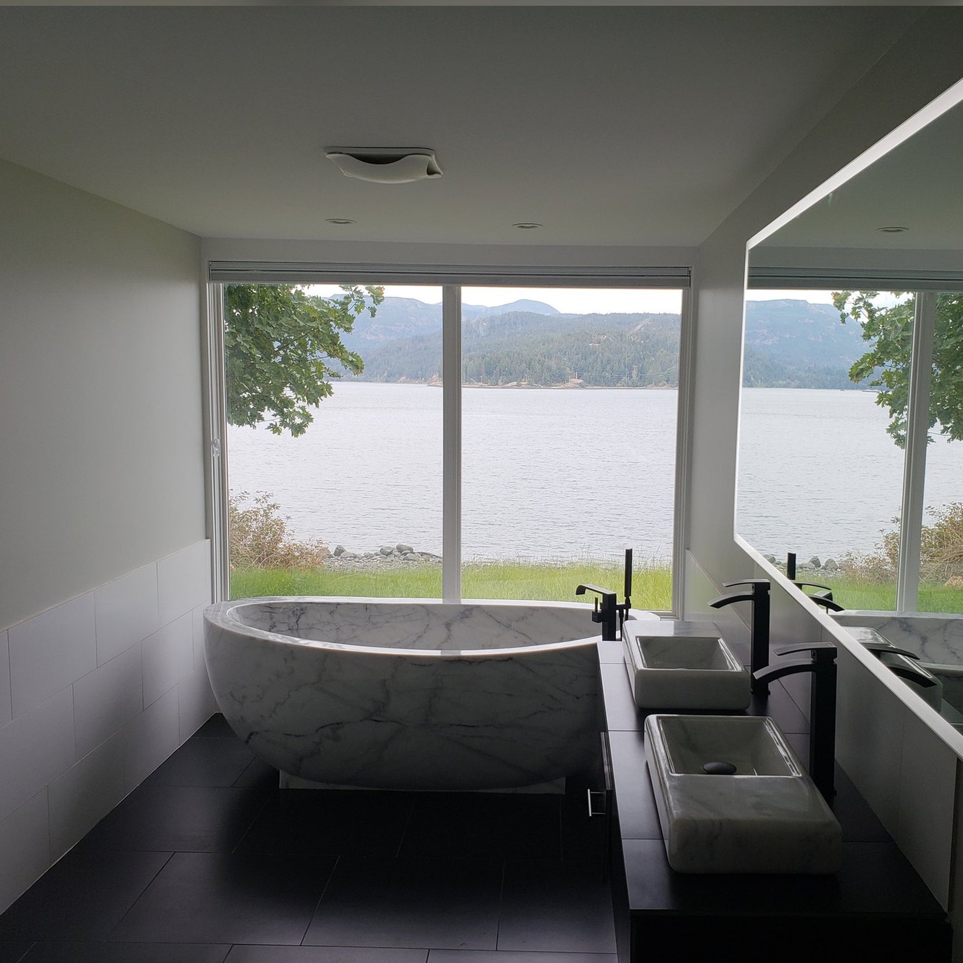Actual installed Aurelia BT-038A Ivory Cloud Marble bathtub in a lake-view residential bathroom