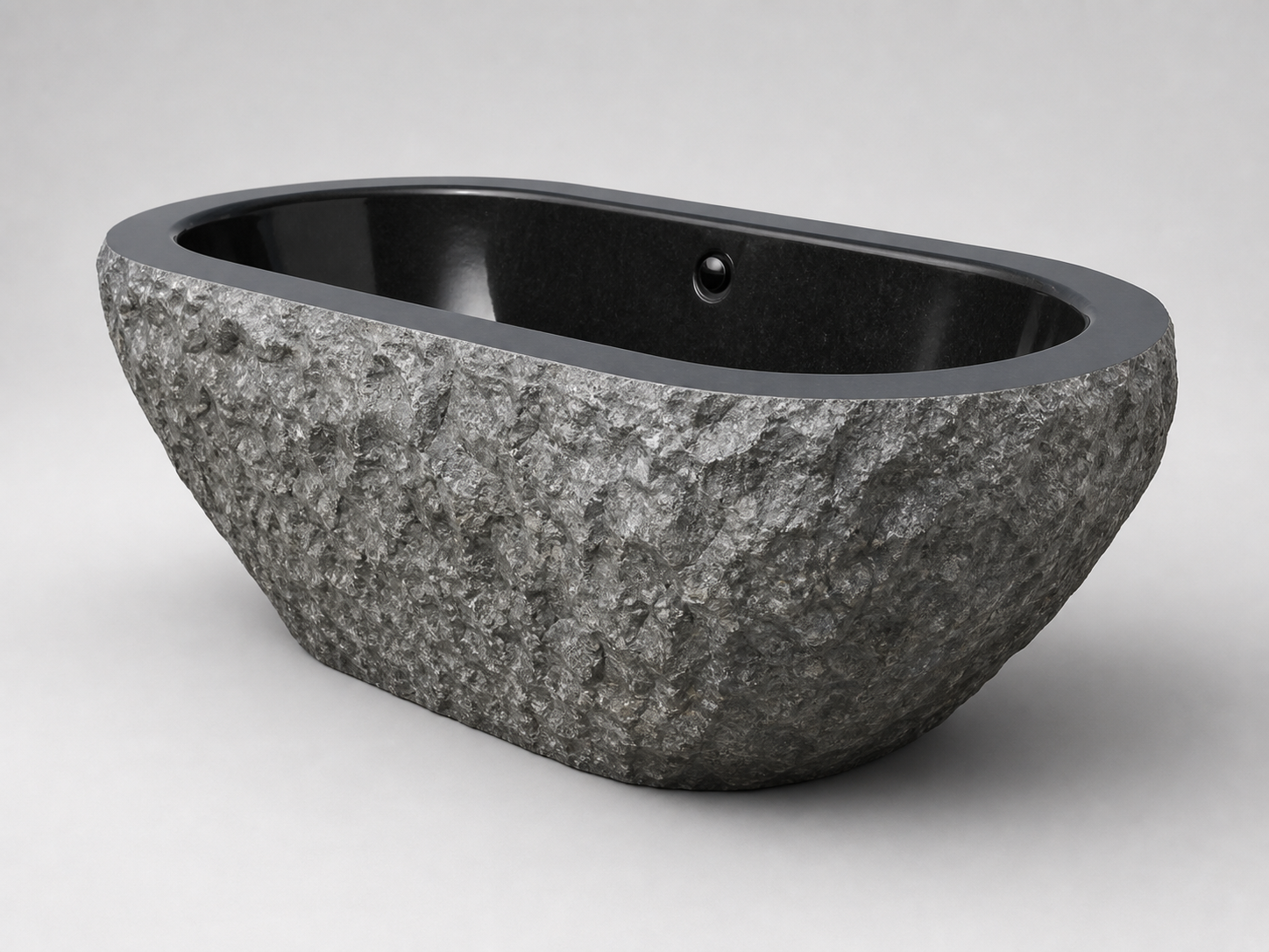Arden natural-face black granite soaking bathtub, opposite studio angle
