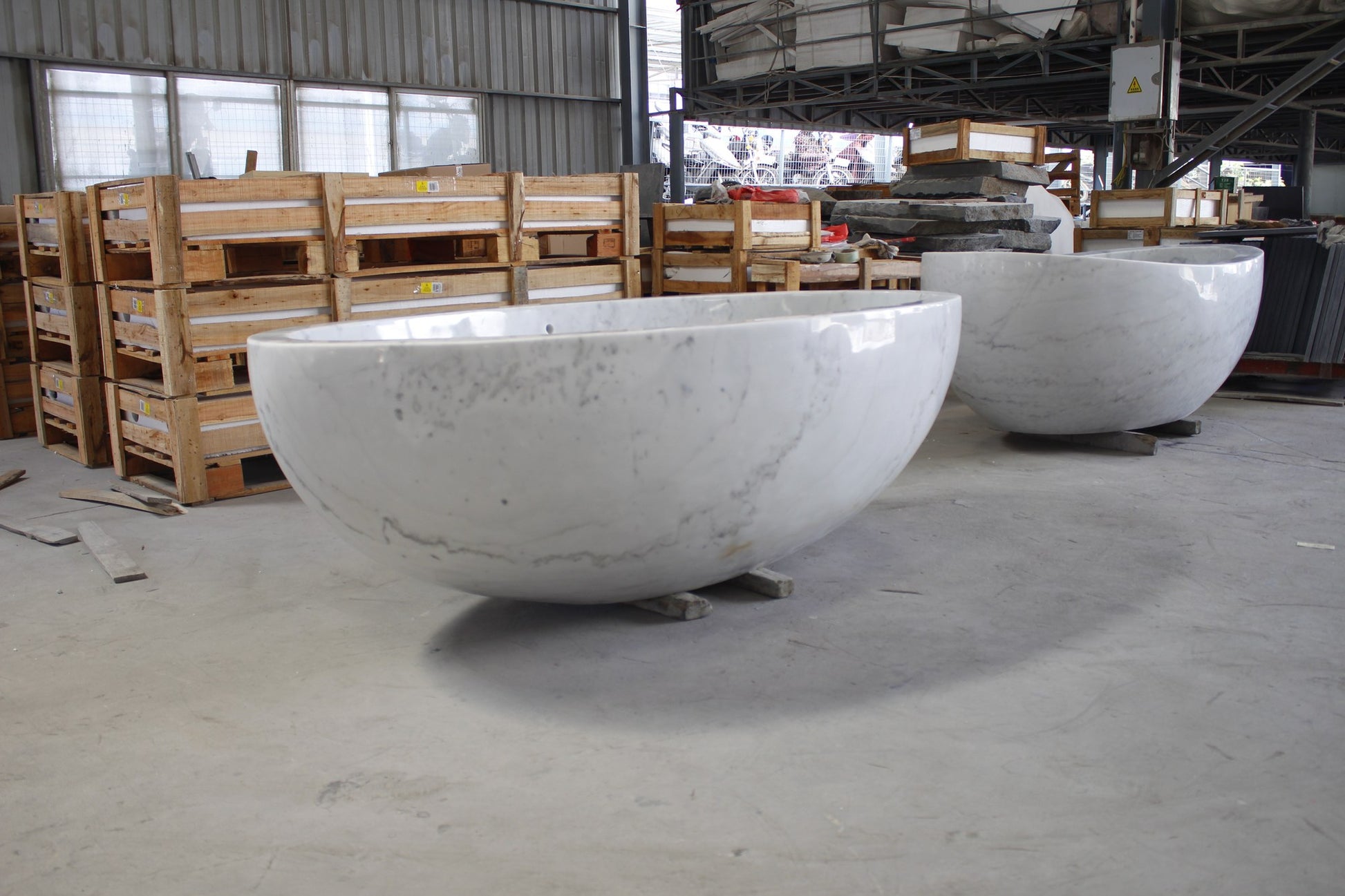 Actual Mira BT-031A Ivory Cloud Marble bathtub at the stone workshop, three-quarter view