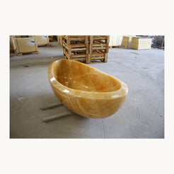 Real angled view of Yuna Honey Onyx bathtub with natural amber and cream veining