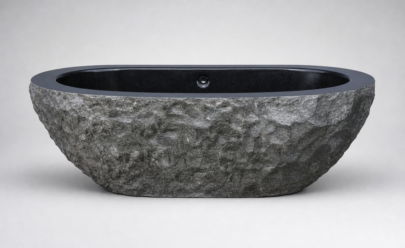 Arden elongated granite bathtub with rugged exterior and polished interior, side profile