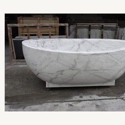 Celeste Ivory Cloud Marble soaking bathtub, real front view with pedestal base