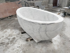 Actual Aurelia BT-038A Ivory Cloud Marble pedestal bathtub at the stone workshop, three-quarter view