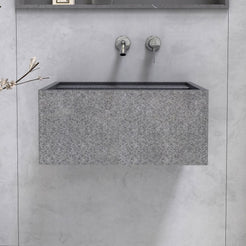Front view of the Tibna Neroco stone sink below a bathroom mirror
