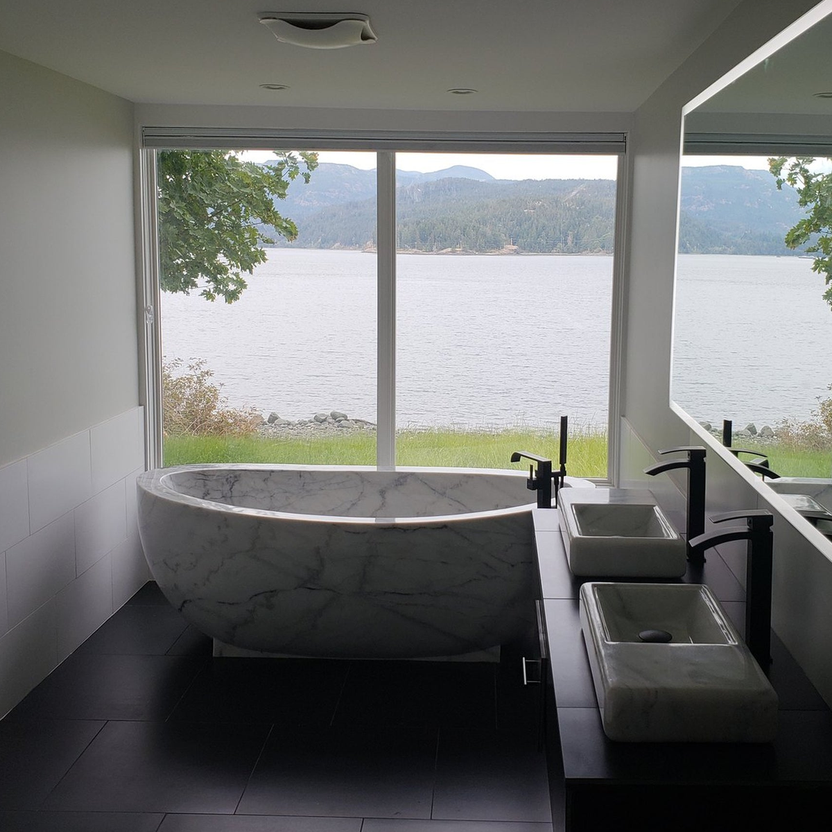 Actual installed Aurelia BT-038A Ivory Cloud Marble bathtub in a lake-view residential bathroom