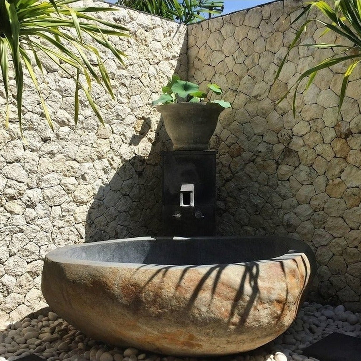 Yitta Filetto Cobble Stone natural stone bathtub installation reference from the supplied project archive, in an outdoor stone-walled setting