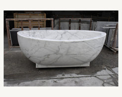 Celeste Ivory Cloud Marble soaking bathtub, real front view with pedestal base