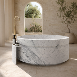 Cirenne Architectural Round Freestanding Soaking Bathtub with Side Ledge – Carrara White Marble in a bright serene courtyard spa bathroom; exact product geometry and material preserved