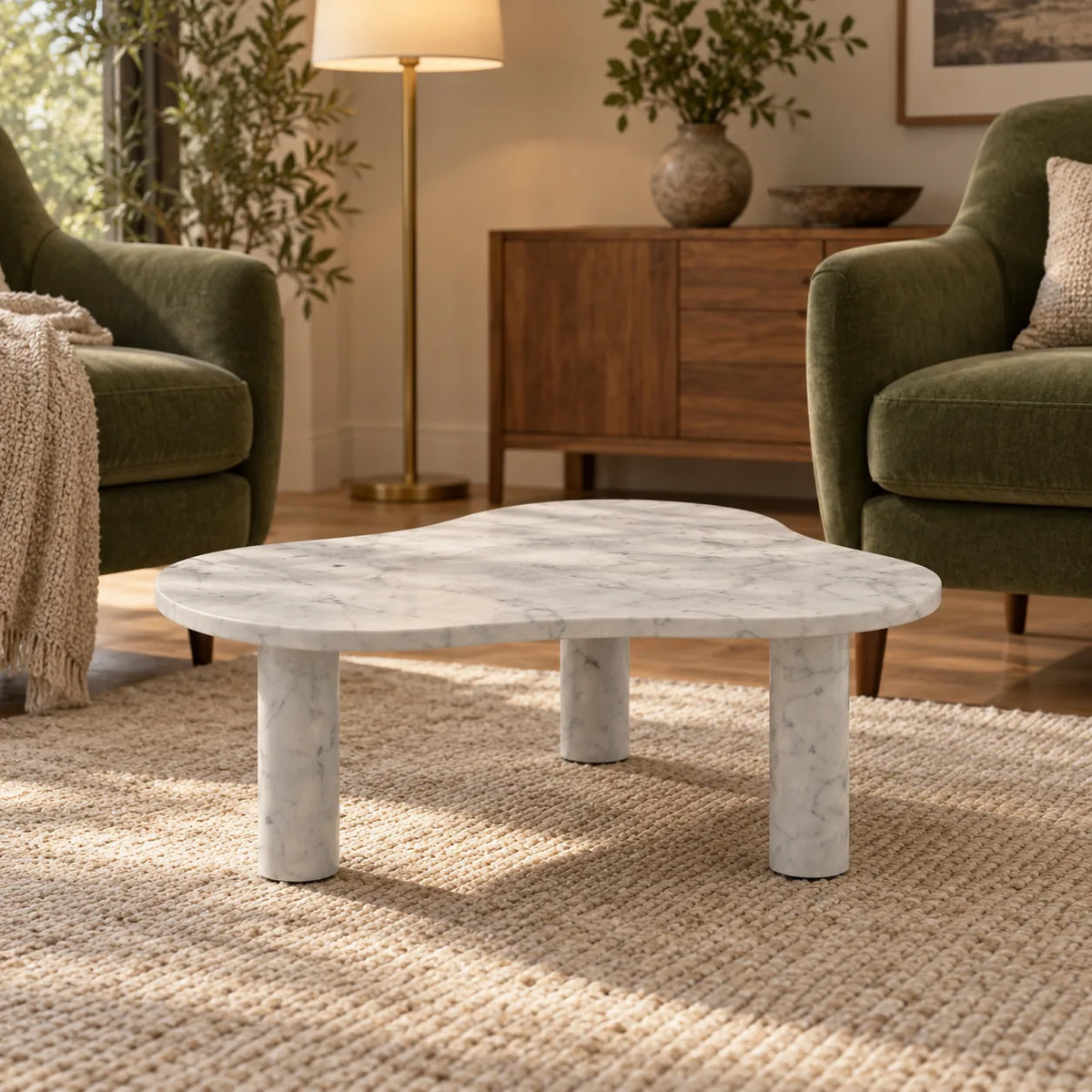 Low front view of the CloudDream Italian Carrara marble coffee table in a moss-green-chair reading lounge, showing its thin free-form top and three stone legs.