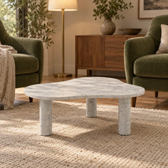 Low front view of the CloudDream Italian Carrara marble coffee table in a moss-green-chair reading lounge, showing its thin free-form top and three stone legs.