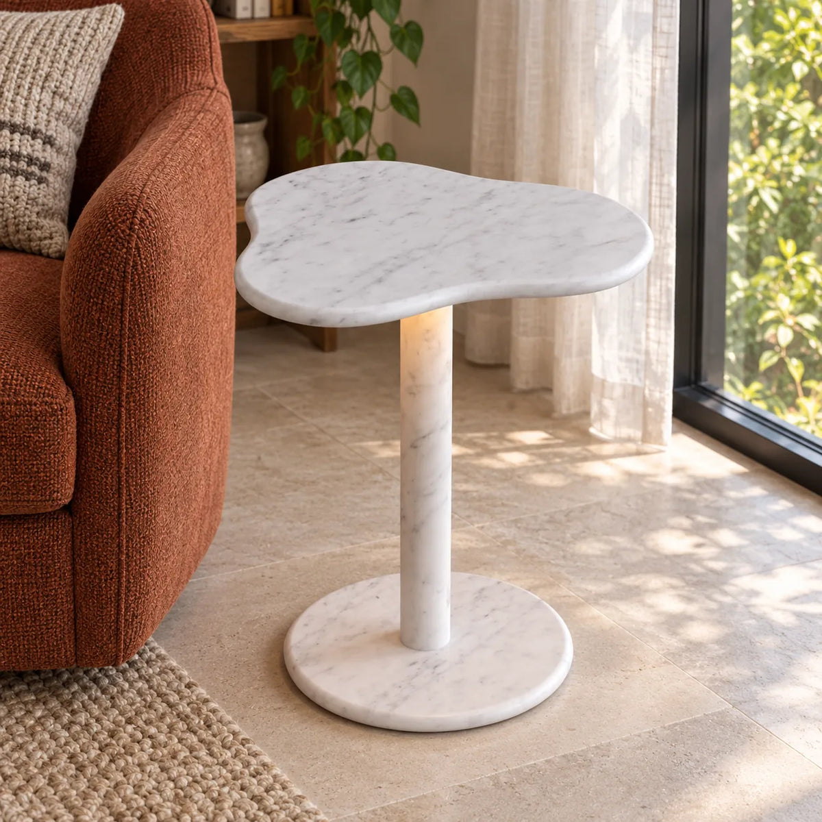 CloudDream Carrara marble smart-edition side table beside a rust reading chair, shown from a high front-quarter view