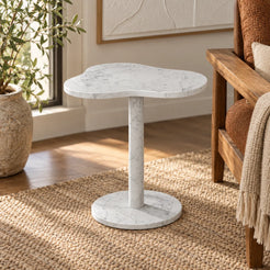 CloudDream Carrara marble side table with a cloud-shaped top and cylindrical pedestal beside a wooden reading bench.