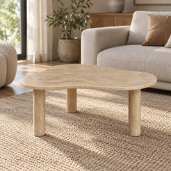 CloudDream Italian Classico travertine coffee table with a thin cloud-shaped top and three cylindrical legs in a warm linen-sofa living room.