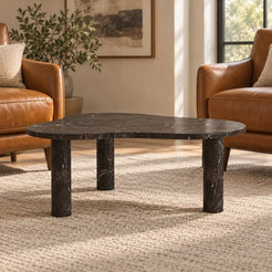 Low front view of the CloudDream Dark Emperador marble coffee table in a leather-chair reading lounge, showing its free-form thin top and three stone supports.