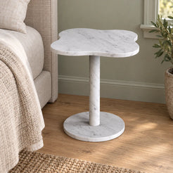 LakeMist Carrara marble side table beside a bed, shown from a moderate oblique view