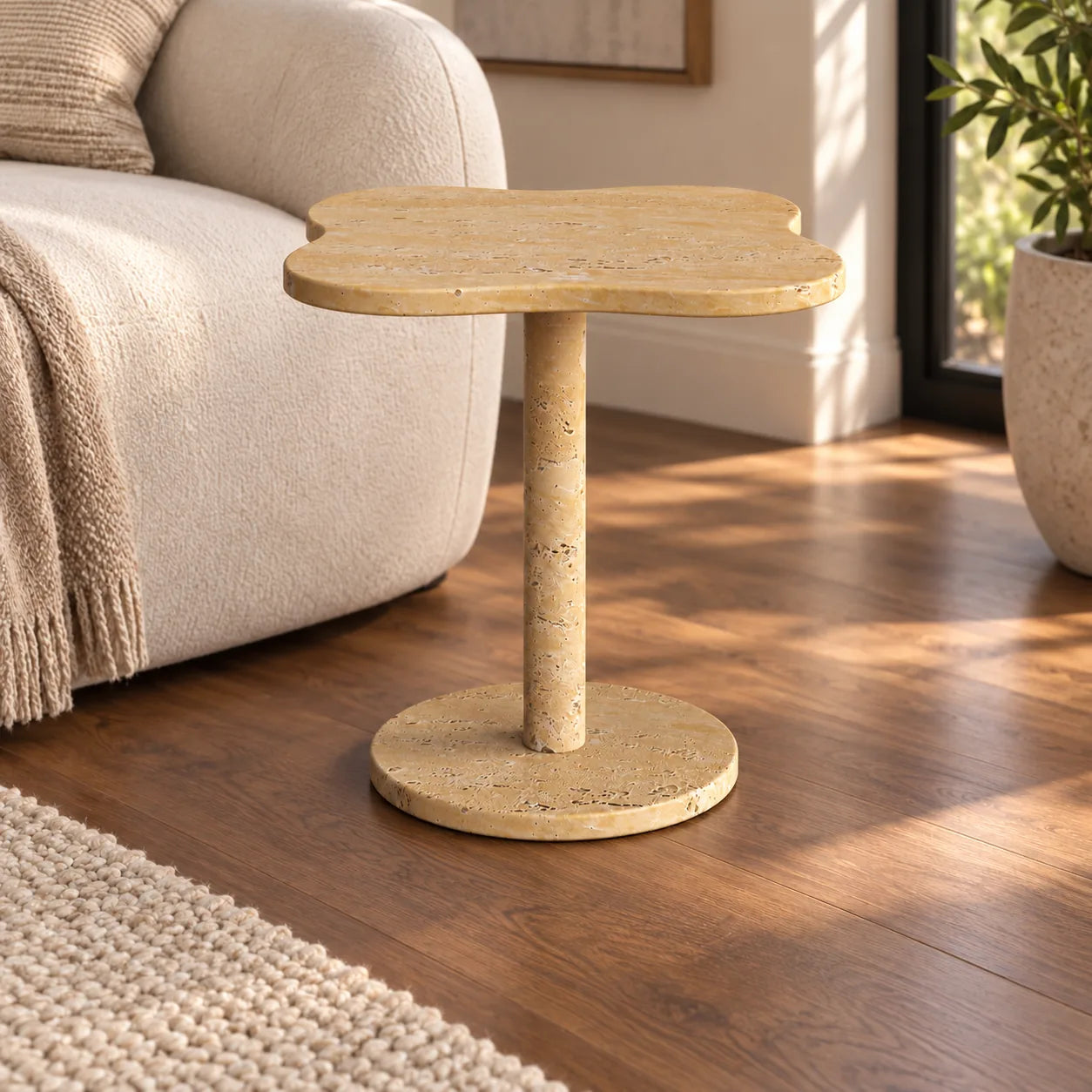 LakeMist Italian Classico travertine side table beside an ivory sofa, shown from a moderate oblique view