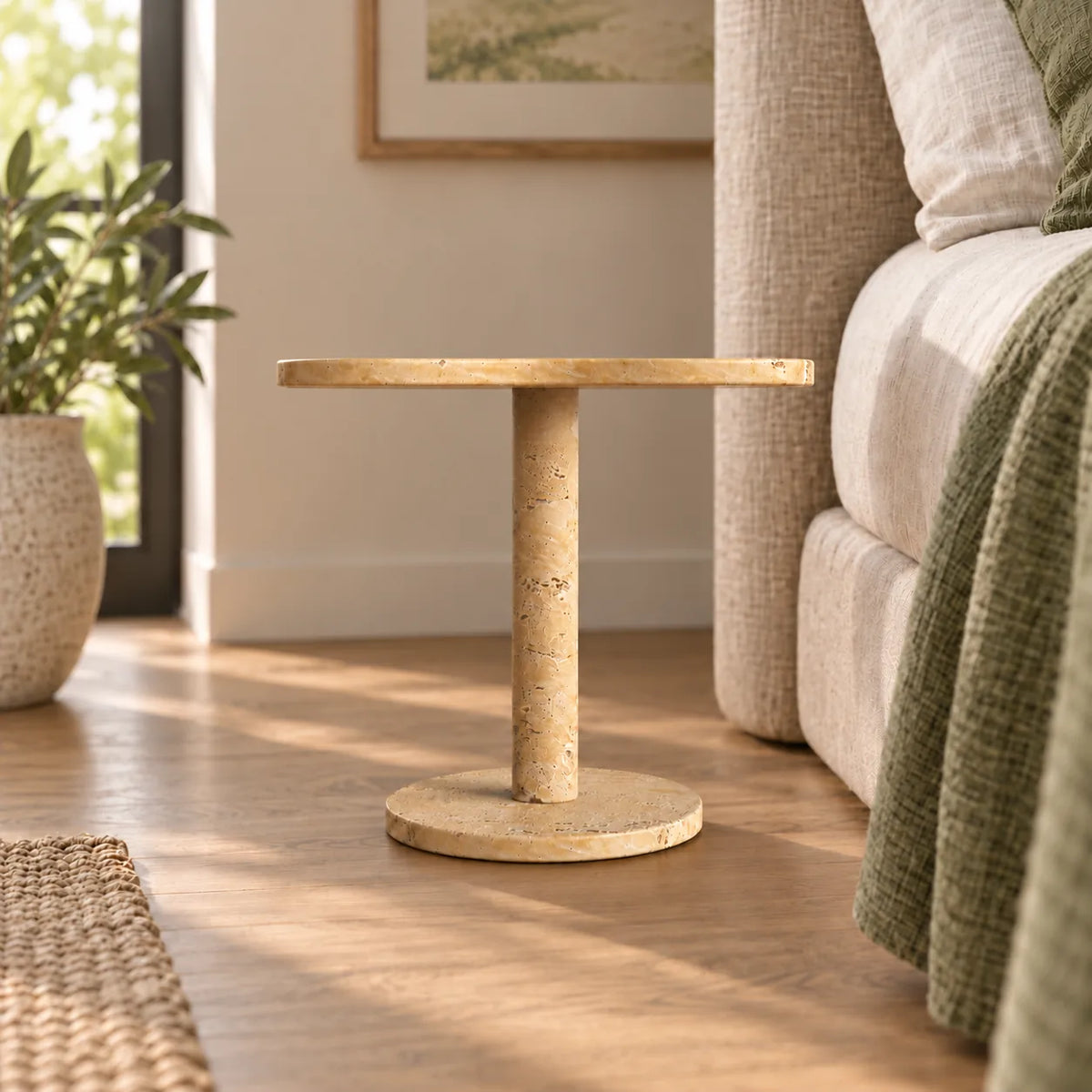 LakeMist Classico travertine side table beside a bed, shown from a low frontal view