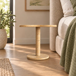 LakeMist Classico travertine side table beside a bed, shown from a low frontal view
