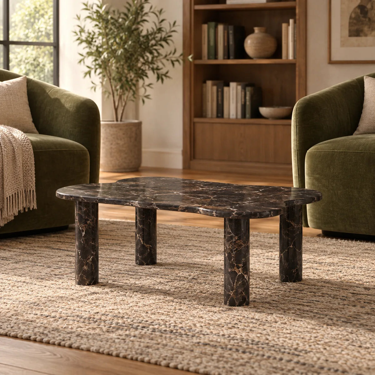 Low front view of the LakeMist Dark Emperador marble coffee table in a reading lounge, showing its wavy stone top and cylindrical supports.