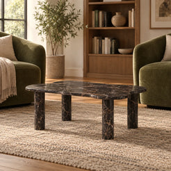 Low front view of the LakeMist Dark Emperador marble coffee table in a reading lounge, showing its wavy stone top and cylindrical supports.