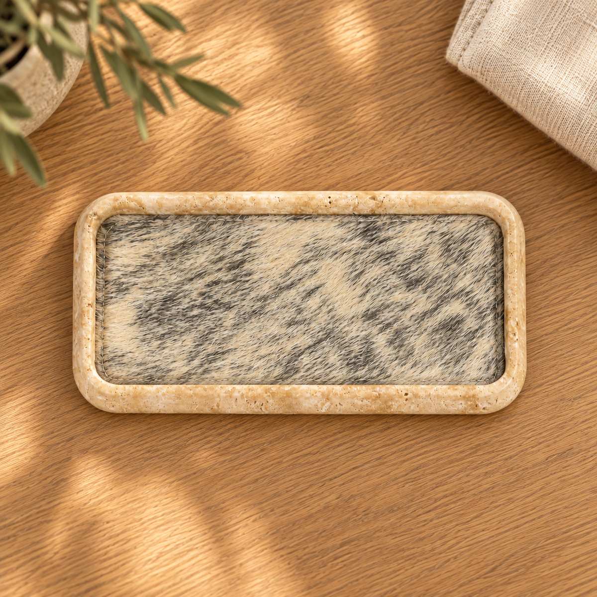 ZenFur beige travertine tray with horse-fur lining, overhead view on warm oak