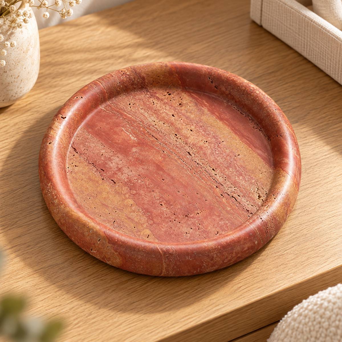 ScarletPebble red travertine round tray, high three-quarter view
