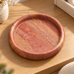 ScarletPebble red travertine round tray, high three-quarter view