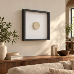 RoundHaven wall frame decor with a Classico travertine circular center, left oblique view in a sunlit warm interior