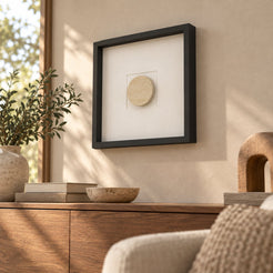 RoundHaven wall frame decor with a Classico travertine circular center, low right oblique view in a sunlit warm interior