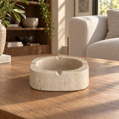 SquareSoft Classico travertine ashtray with four rim rests, low front view in a warm natural-light interior