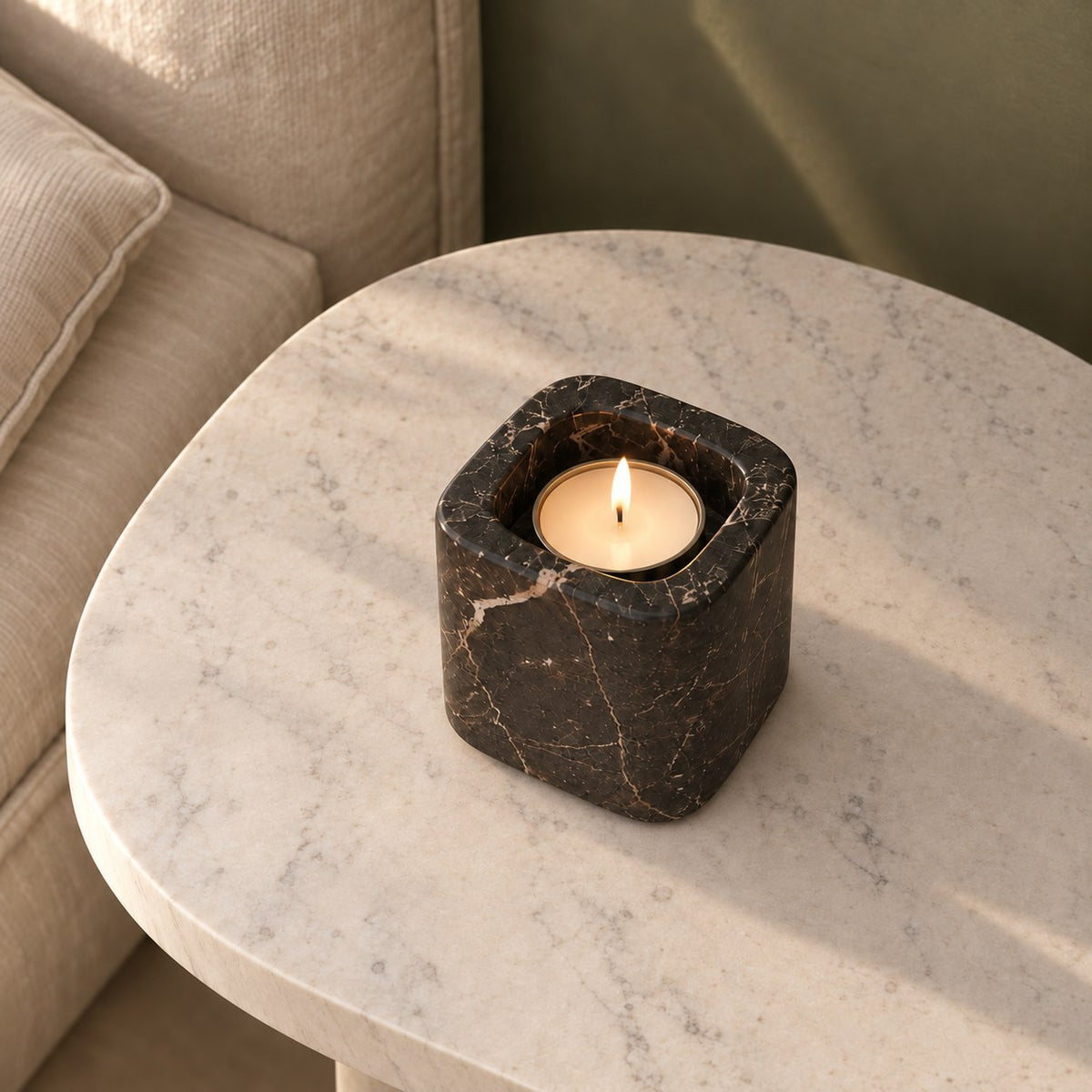 One Tall SquareSoft Spanish Emperador marble candle holder with a lit tealight, high oblique view on a warm stone table