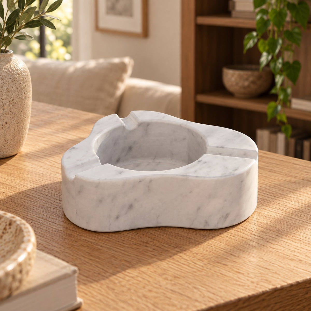 CloudDream Italian Carrara marble stone ashtray, low front view in a warm naturally lit interior