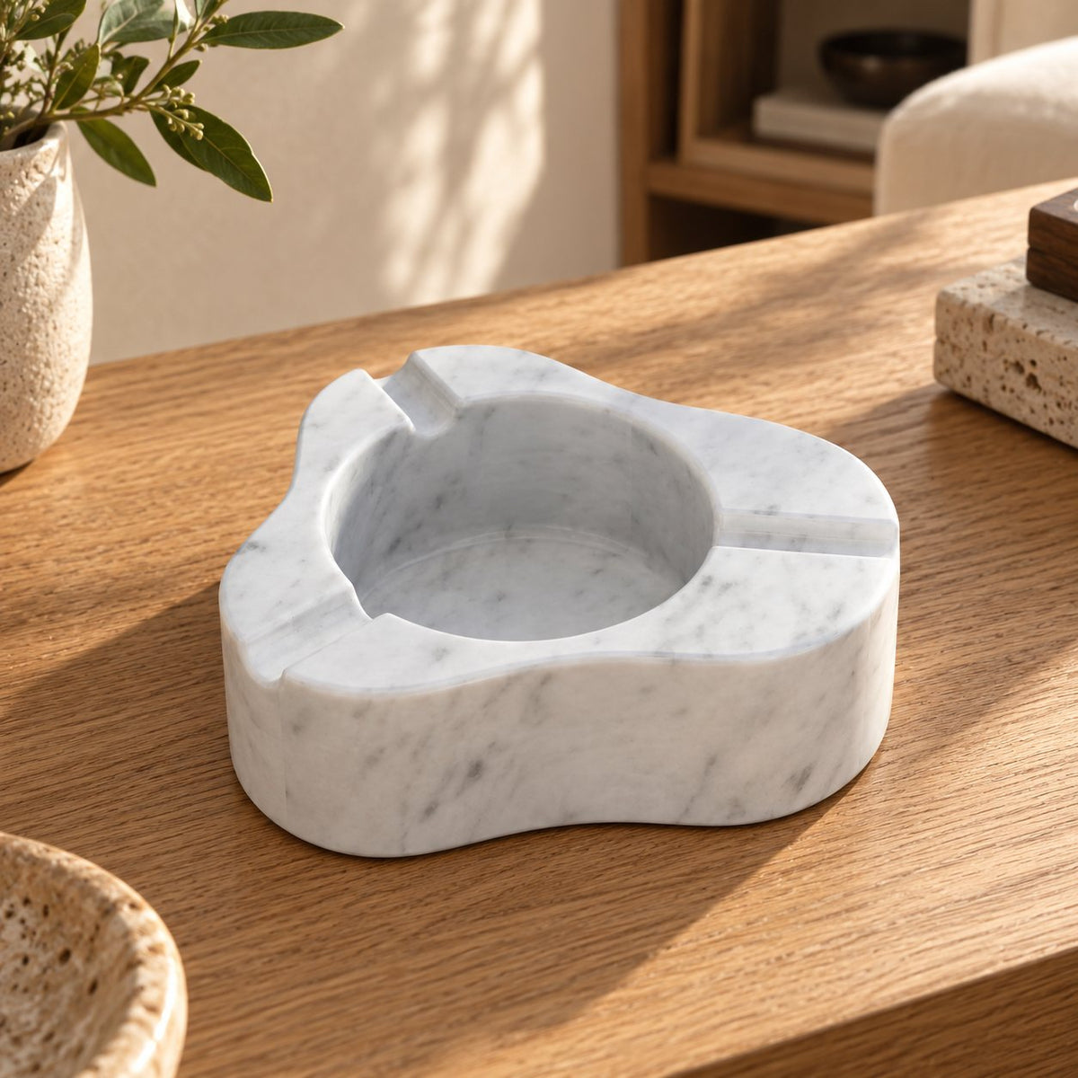 CloudDream Italian Carrara marble stone ashtray, oblique view in a warm naturally lit interior