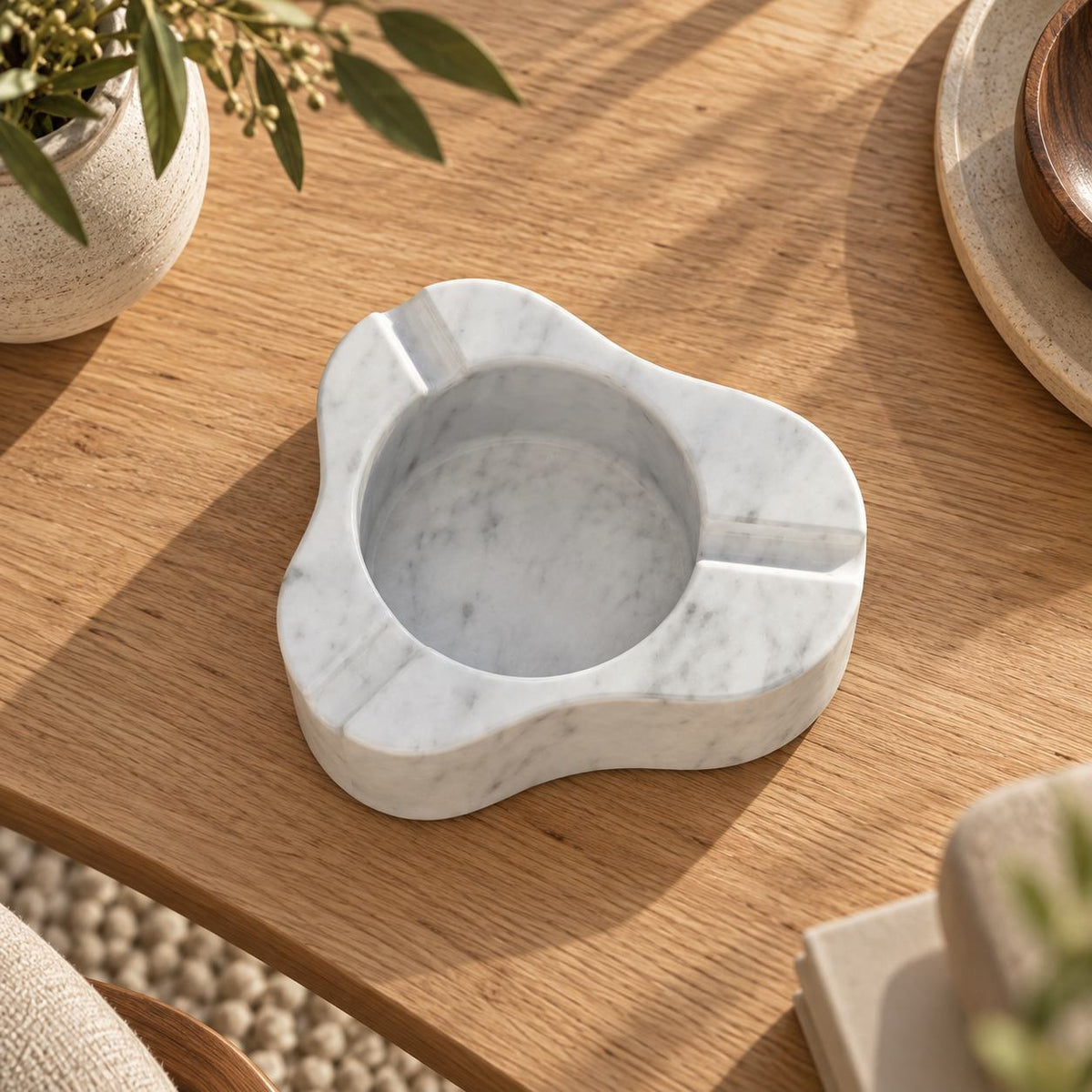 CloudDream Italian Carrara marble stone ashtray, high overhead view in a warm naturally lit interior