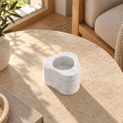 CloudDream Tall Carrara marble candle holder, high opposite view in a warm natural-light interior