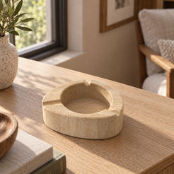 SwanEgg Marble Ashtray, Italian Classico Travertine, single configuration, left oblique view in a warm naturally lit interior