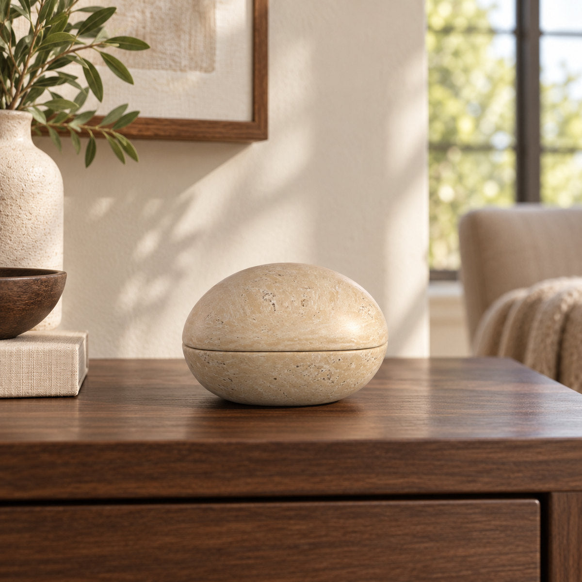 SwanEgg Marble Decor, Italian Classico Travertine, one closed ornament, low end-on view in a warm naturally lit interior