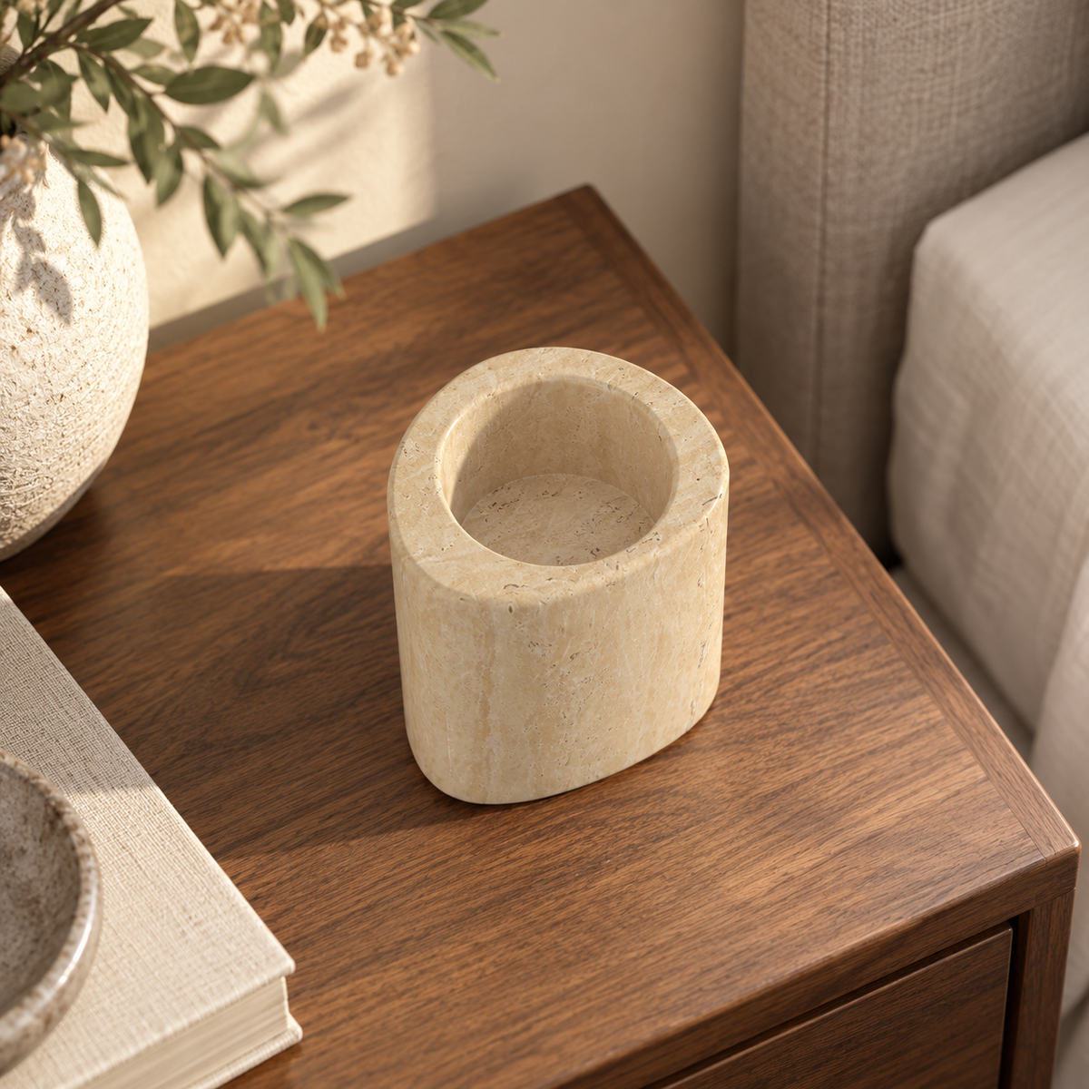 SwanEgg candle holder, Tall Italian Classico Travertine, one holder, high left oblique view in a warm naturally lit interior