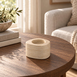 ZenPebble Candle Holders, Italian Classico Travertine / Short, single configuration, left oblique view in a warm naturally lit interior