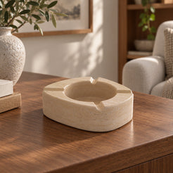 ZenPebble ashtray, Italian Classico Travertine, single ashtray with four rim rests, low front view in warm natural light