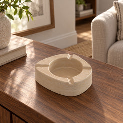 ZenPebble ashtray, Italian Classico Travertine, single ashtray with four rim rests, high left oblique view in warm natural light