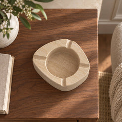 ZenPebble ashtray, Italian Classico Travertine, single ashtray with four rim rests, overhead view in warm natural light