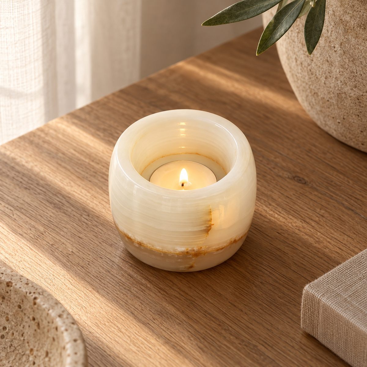 Luxury Lumi White Onyx Candle Holder, high left Lumi open cup, warm natural light in a premium home interior
