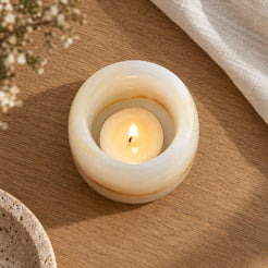 Luxury Lumi White Onyx Candle Holder, overhead Lumi circular cup, warm natural light in a premium home interior