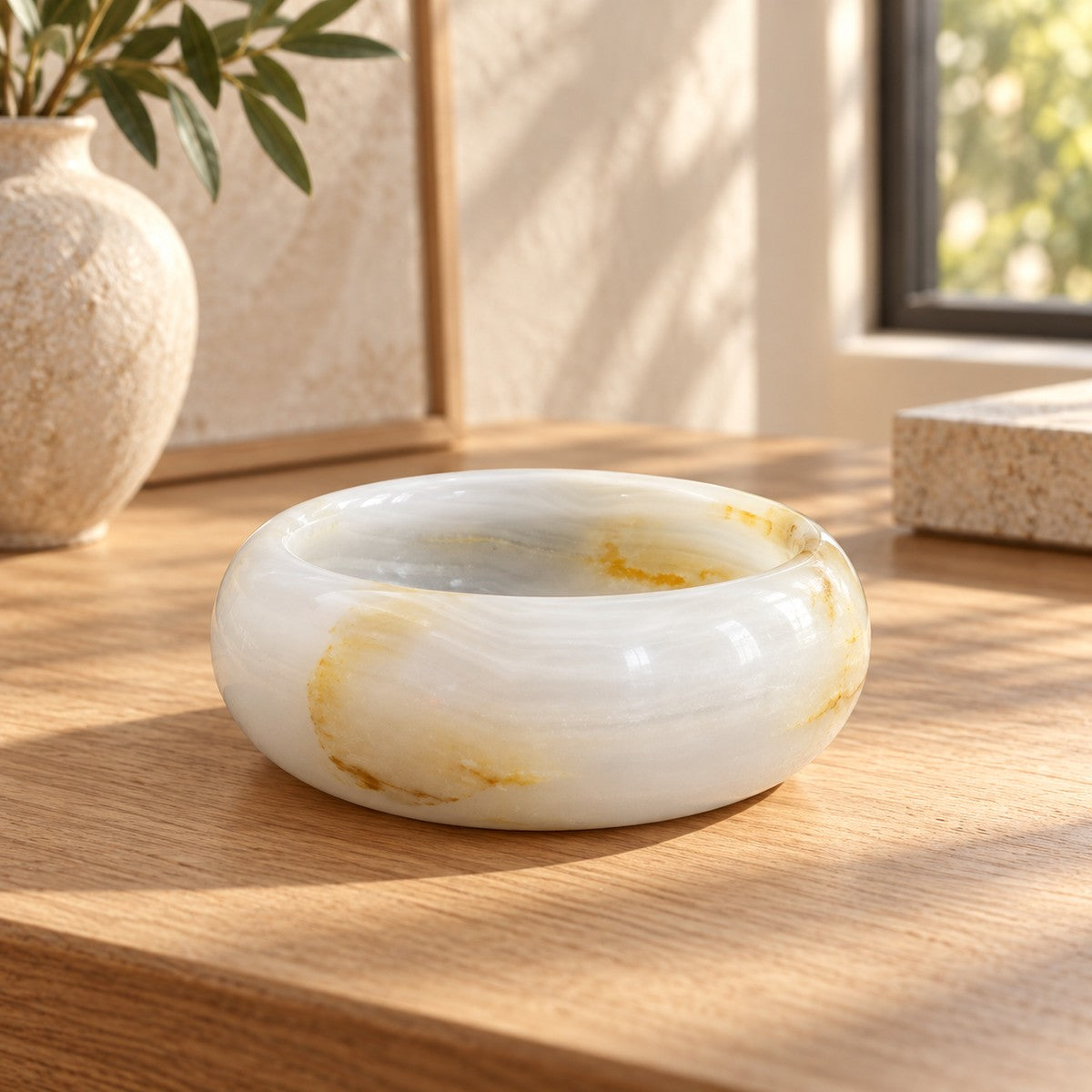 Aura Round Onyx Ashtray, low frontal white-onyx Aura Hero, warm natural light in a premium home interior
